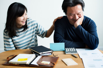 Couple sitting at kitchen table makes a household budget together.