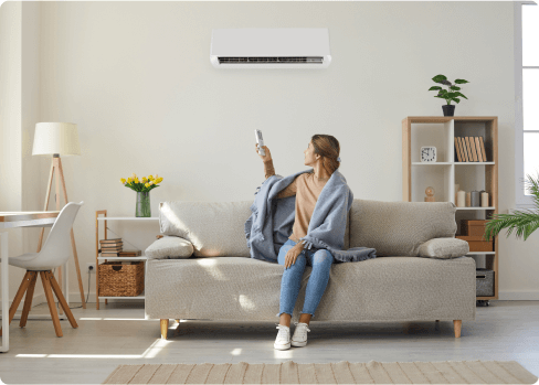 A woman uses a remote to turn on the air conditioner in her energy-efficient home