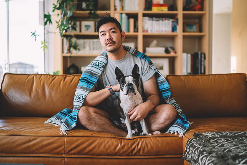 A homeowner sitting on the couch with his dog