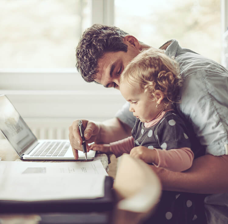 A homeowner with a child on his lap calculating whether to buy a new home or refinance his home loan
