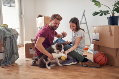 Millennial first-time homebuyers move into their new home with dog.