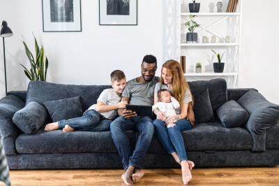 A family sitting on the couch learning their next steps to buying a home
