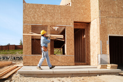 Worker carries wood for a home construction project.