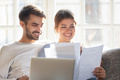 Couple reads tax benefits of owning a home paperwork together