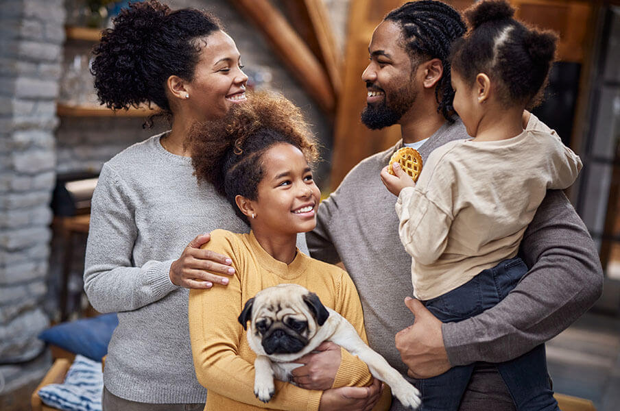 Parents and their two children pose together with their dog