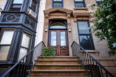 The front stoop of a co-op apartment building in New York City that is available to buy.