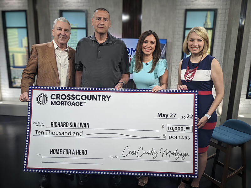 Homes for Hero winner, Rick Sullivan, holding his large check with Alicia Gauer and Fox 8 anchors