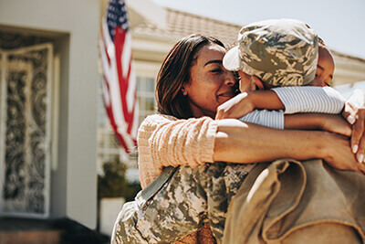 Veteran hugging his family
