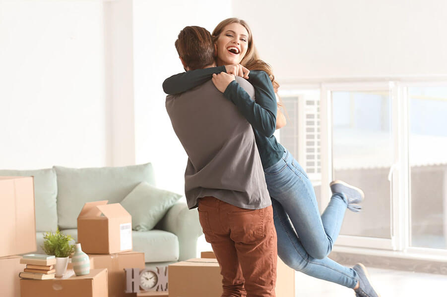 Couple hugs after moving into new home using CCM CashPlus mortgage loan product