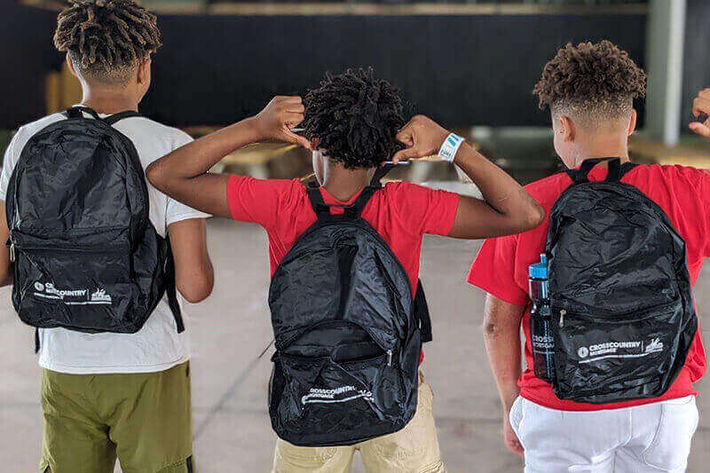 Three participants of the back-to-school giveaways with their prizes